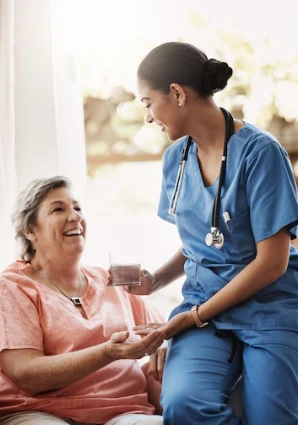 A private caregiver in conversation with an elderly woman, providing care and support in a healthcare setting.